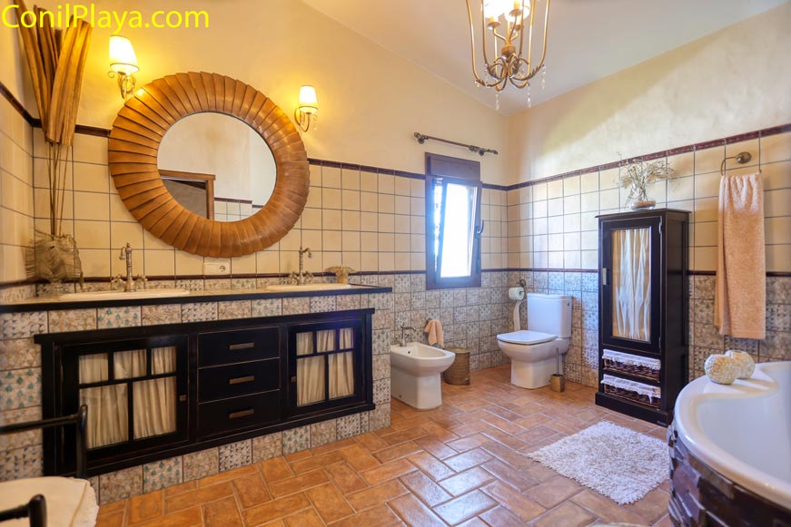 Cuarto de baño amplio con ventana, bañera y decoración rústica elegante