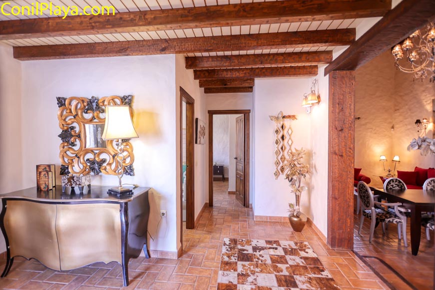 Salón vista desde el pasillo con mesa, decoración y vigas de madera