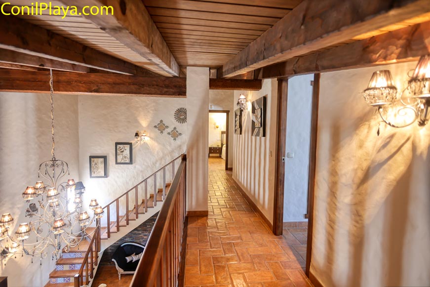 Pasillo interior con techo de madera en planta superior y acceso a dormitorio