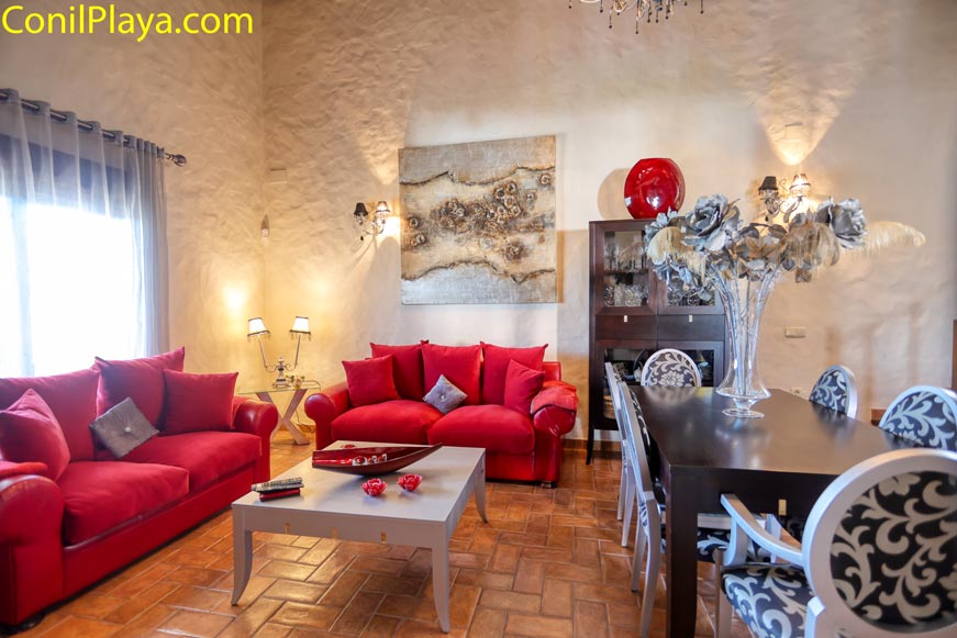 Salón con sofás rojos y mesa comedor visto desde la entrada