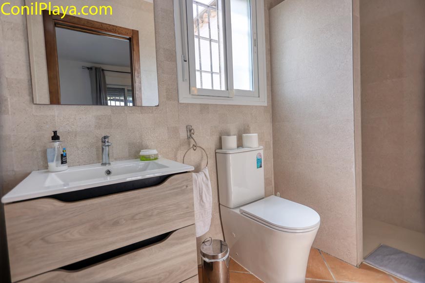 Baño moderno con mueble de madera, lavabo encastrado y espejo