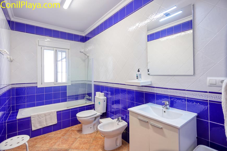 Baño completo con bañera, bidé y azulejos azules