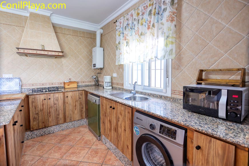 Detalle de cocina equipada con lavadora, lavavajillas y microondas