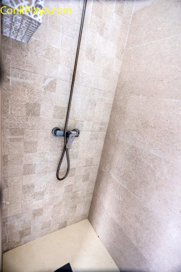 Zona de ducha con revestimiento cerámico y grifería monomando