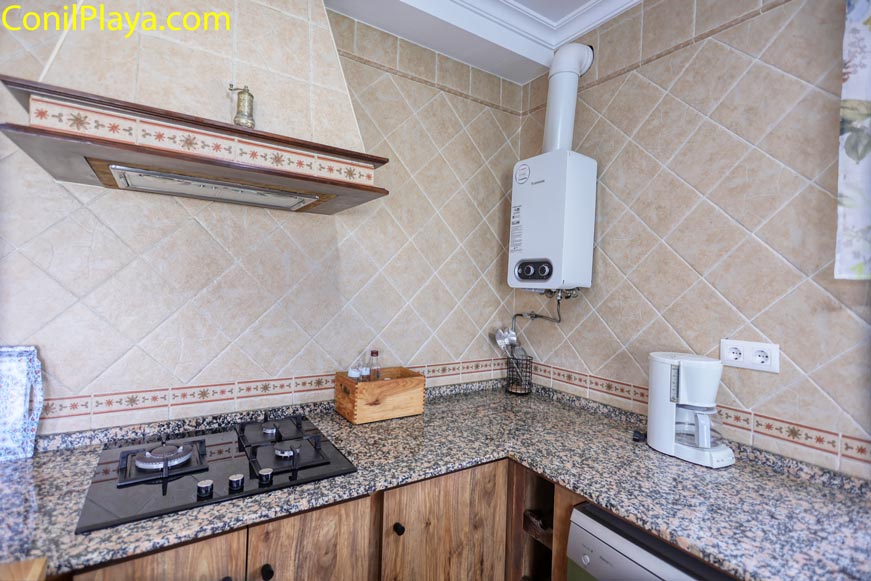 Placa de cocina de gas, cafetera y extractor en cocina rústica