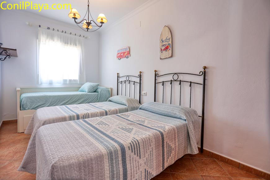 Habitación con tres camas individuales con cabeceros de hierro