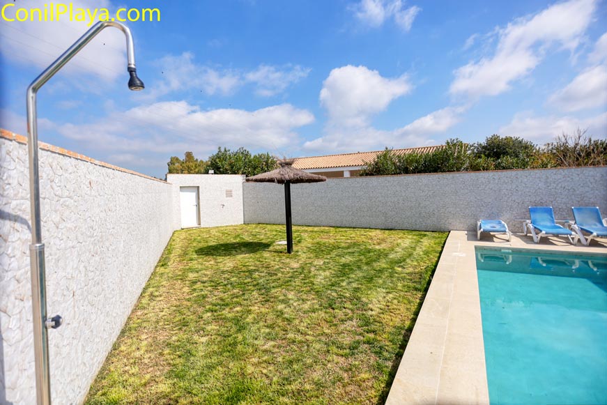 Ducha de acero inoxidable en la zona de jardín junto a la piscina