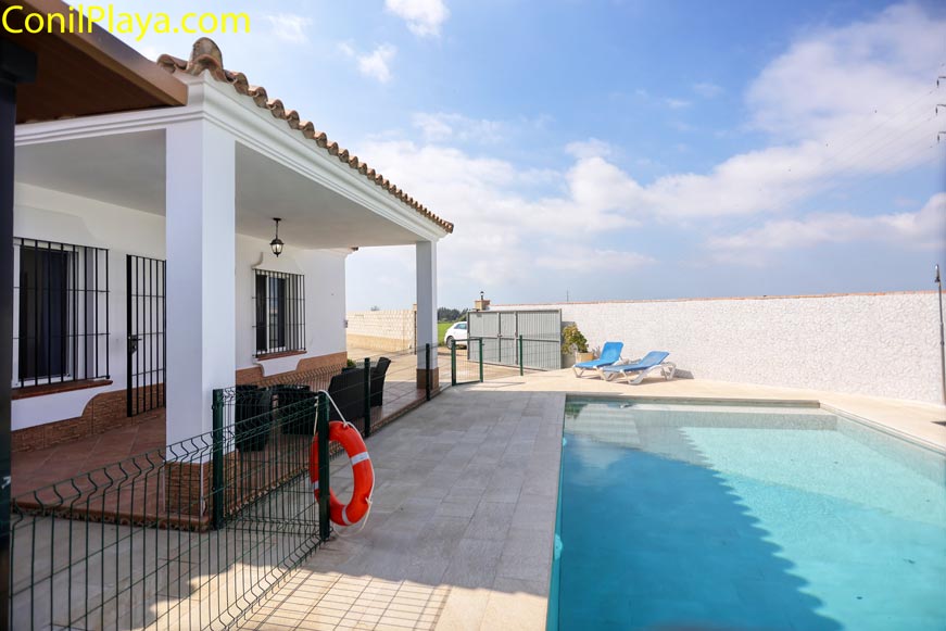 Fachada andaluza blanca junto a la piscina vallada