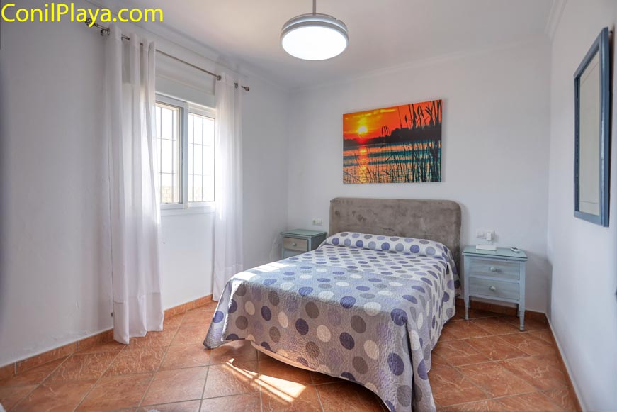 Dormitorio con cama de matrimonio y cuadro decorativo