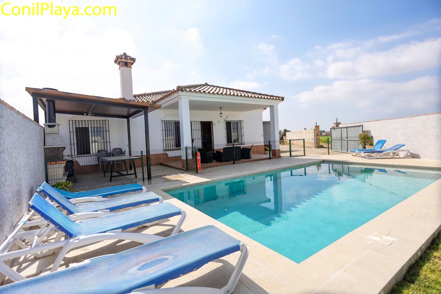 Zona de solárium junto a la piscina con cómodas tumbonas