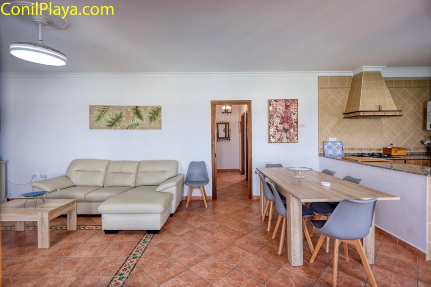 Salón comedor luminoso con mesa de madera y cocina integrada