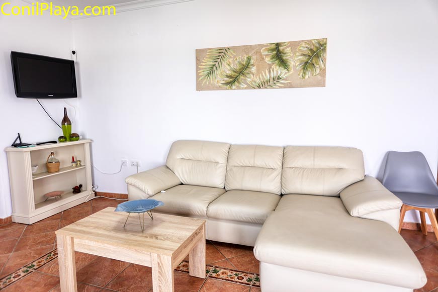 Detalle del amplio sofá chaise longue en la zona de televisión