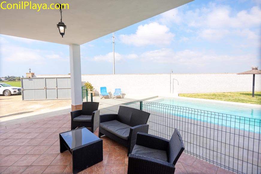 Zona de relax en el porche con mobiliario moderno de jardín