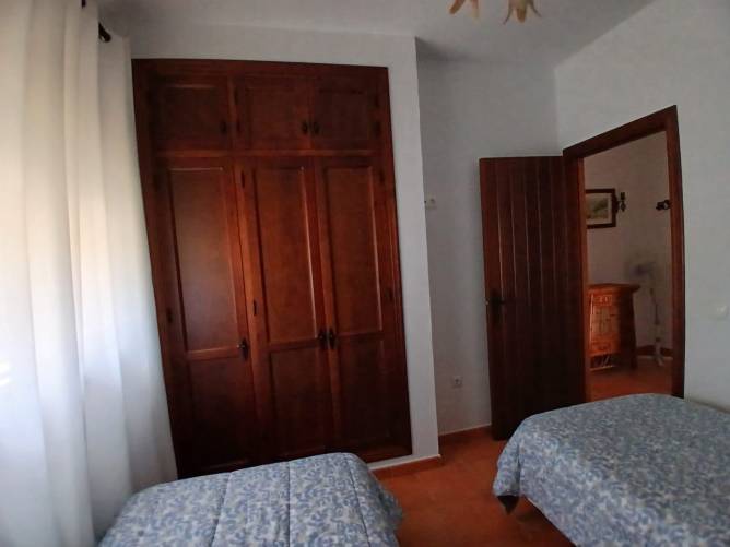 Dormitorio con dos camas individuales y gran armario de madera empotrado
