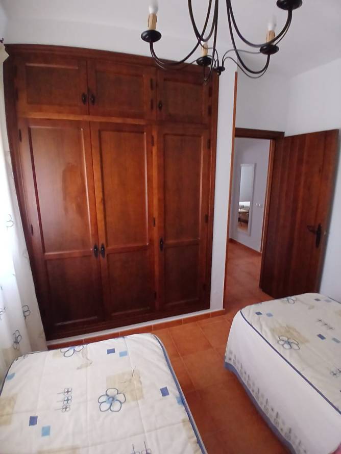 Dormitorio con armario empotrado de madera y dos camas individuales