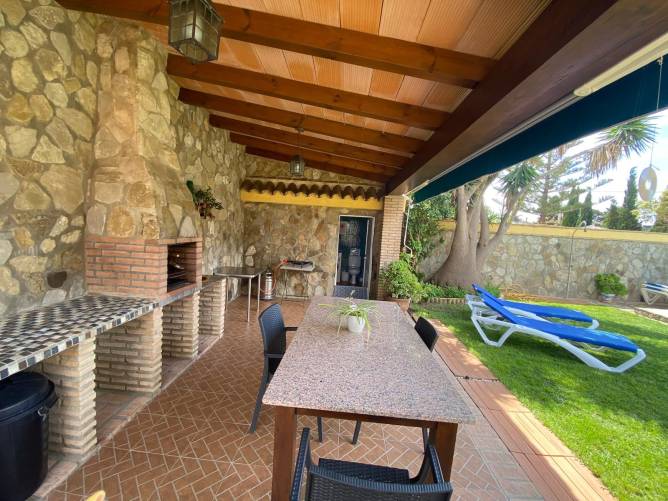 Porche cubierto con mesa barbacoa y vistas al jardín privado