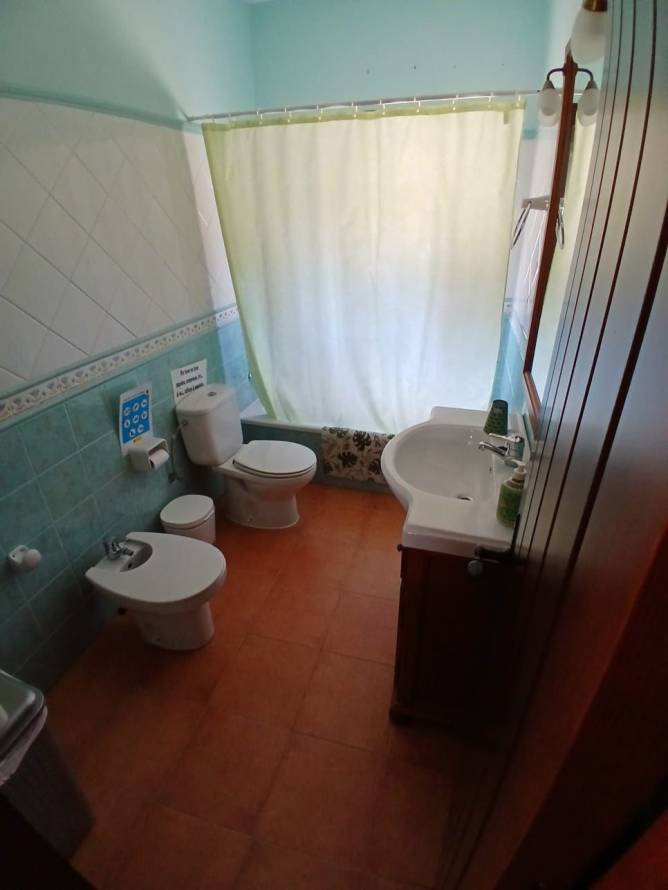Cuarto de baño con ducha, bidé y lavabo visto desde la entrada