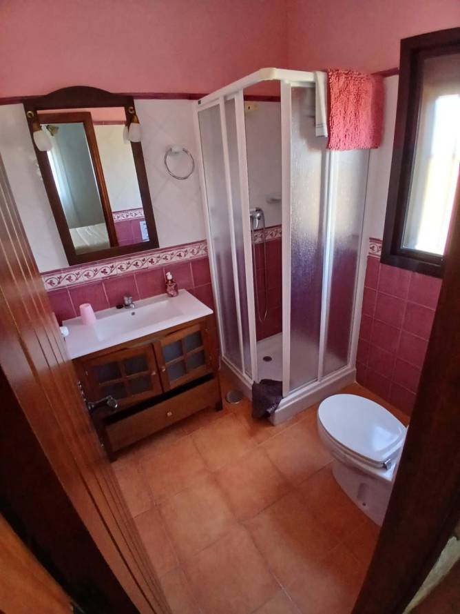 Cuarto de baño con ducha y lavabo visto desde la puerta