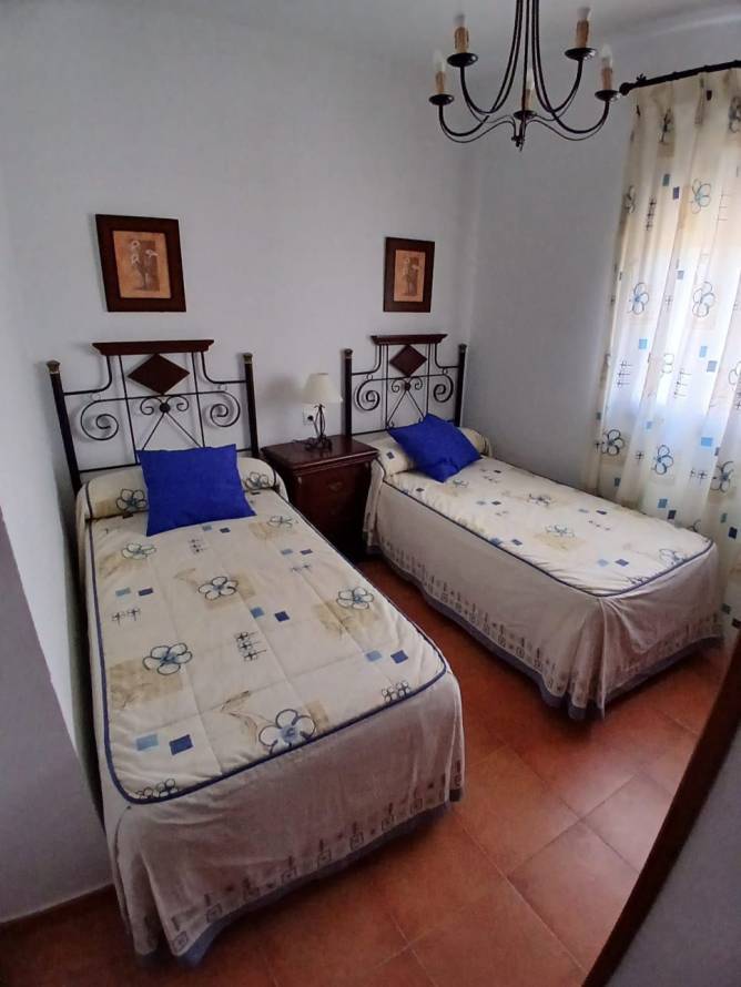 Dormitorio con dos camas individuales y ventana con cortinas decorativas