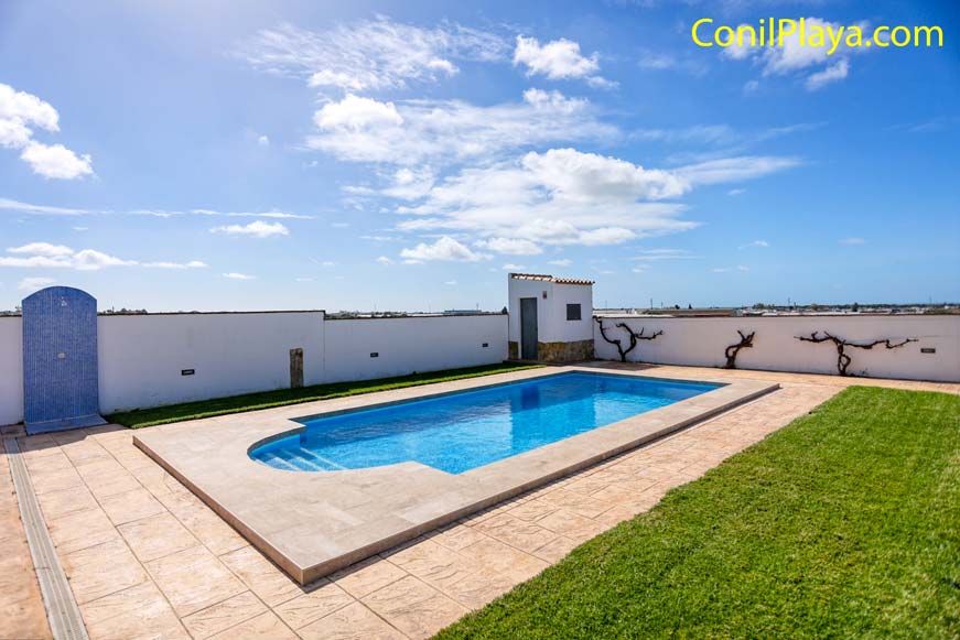 La piscina cuenta con hamacas, a la derecha está la barbacoa.