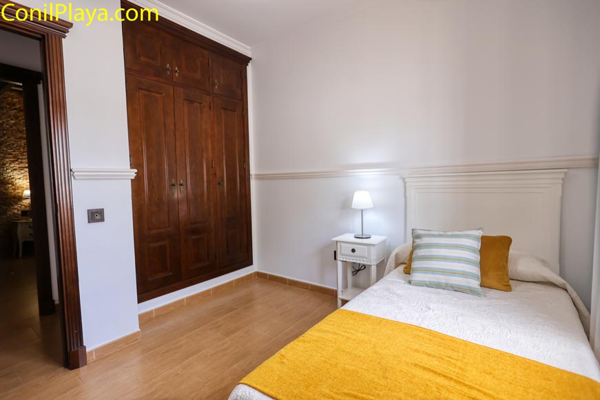 Dormitorio individual con armario empotrado y decoración moderna vista desde la puerta
