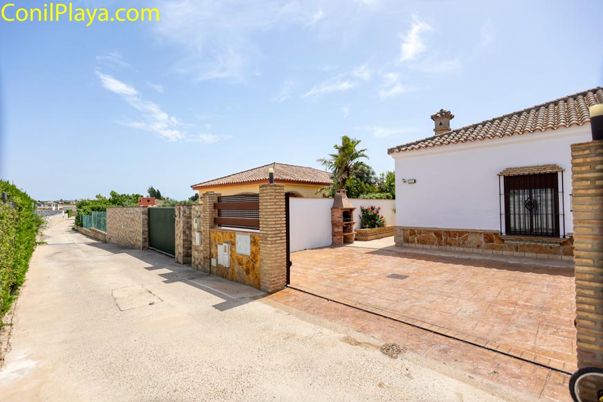 Aparcamiento privado de chalet junto a la calle de acceso pavimentada