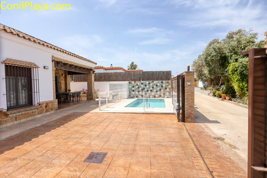 Imagen de la piscina y terraza de una casa vista desde la entrada