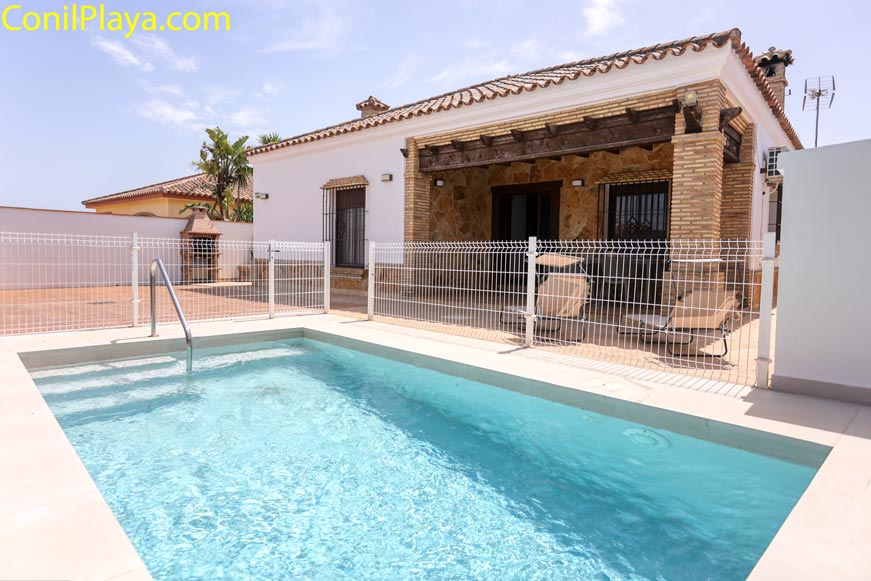 Piscina privada vallada junto al porche de un chalet en Conil en alquiler