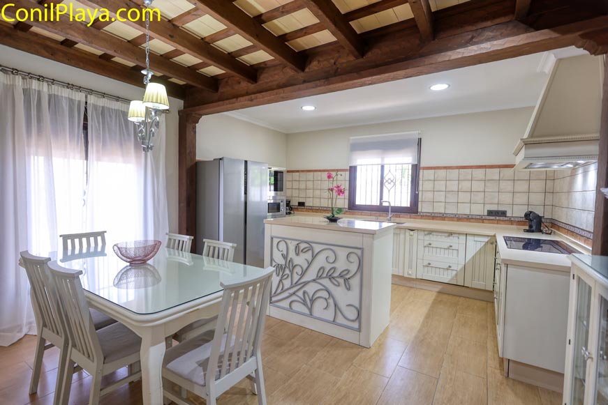 Cocina luminosa con isla decorativa y mesa comedor junto a ventana