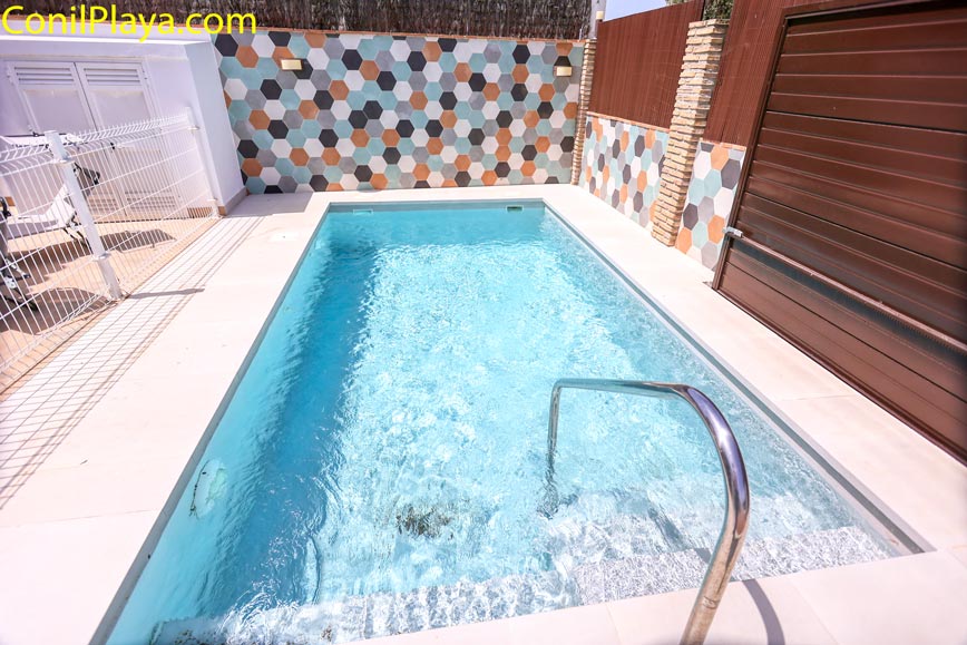 Piscina privada con escalones rodeada de paredes con azulejos hexagonales