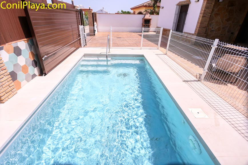 Piscina privada vallada junto a la vivienda vista desde la entrada exterior