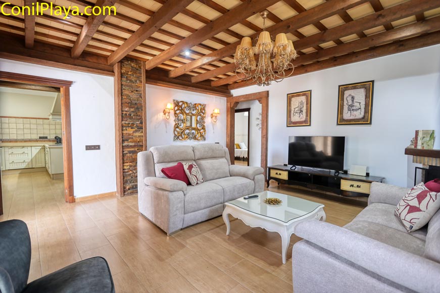 Salón con techo de madera y sofá visto desde la entrada principal