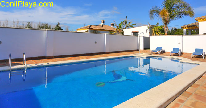 piscina y al fondo el chalet.