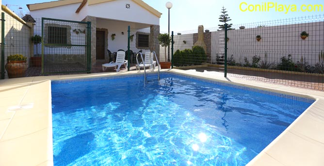 La piscina y el chalet al fondo.