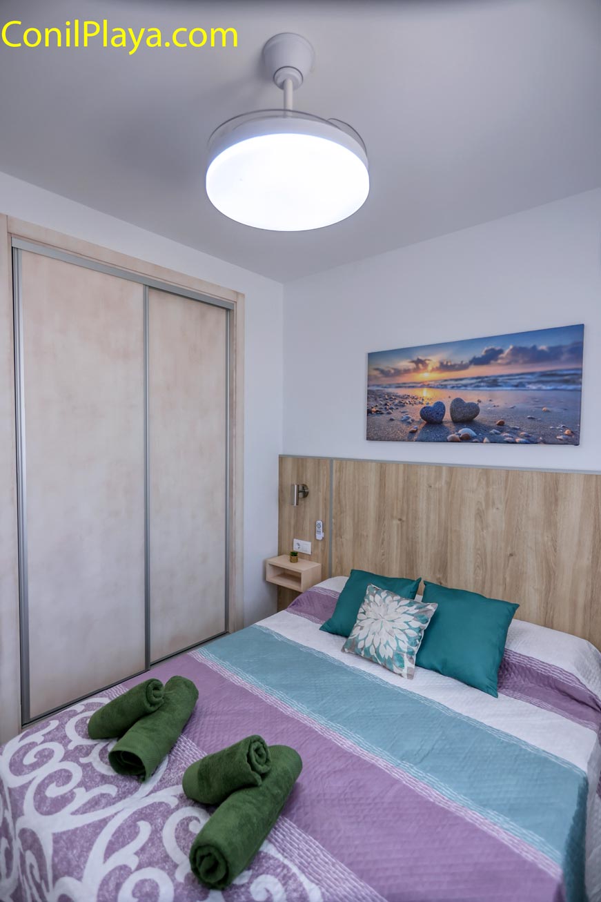 Dormitorio con cama doble y armario empotrado vista desde un lateral