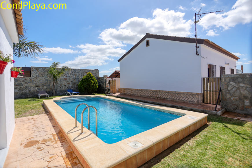 Piscina privada junto a casa con césped y cielo despejado