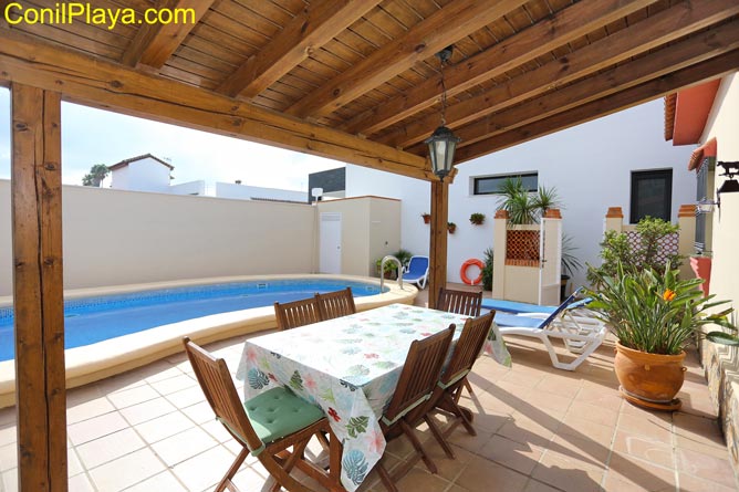 porche con mesa y sillas, enfrente la piscina