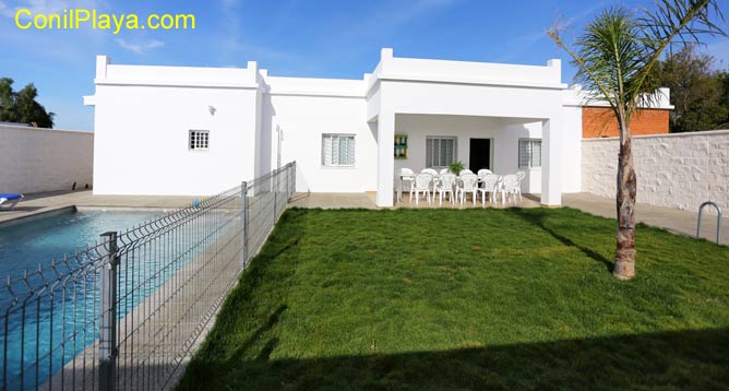 chalet con piscina vallada y jardín con césped