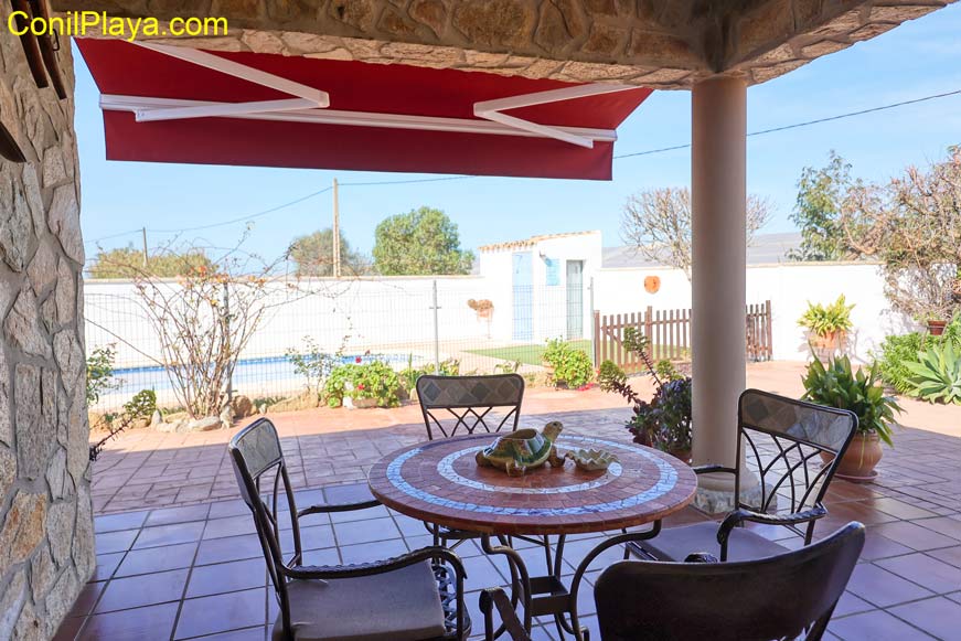 porche con mesa y sillas frente a la piscina