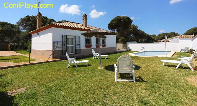 piscina del chalet y tumbonas sobre el césped