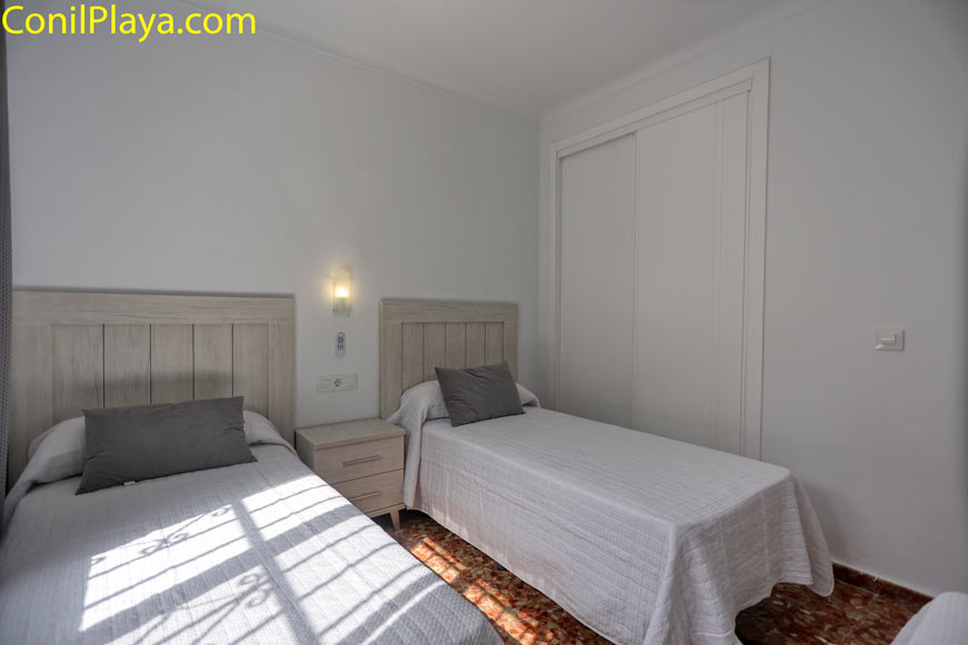 Dormitorio con dos camas individuales y armario empotrado blanco