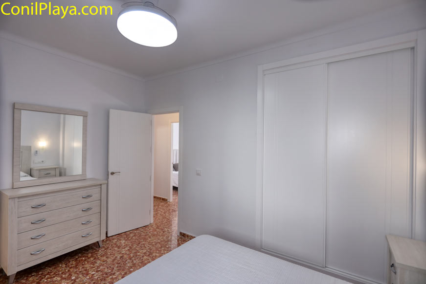 Dormitorio con armario empotrado visto desde la cama y cómoda con espejo