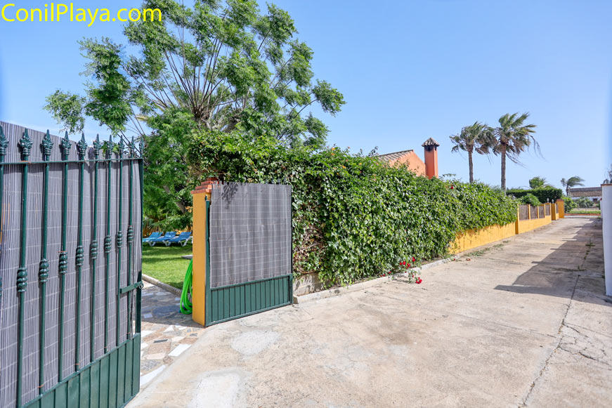 Entrada de aparcamiento privado junto a jardín y valla vegetal