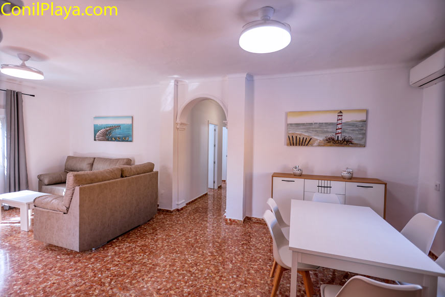 Salón con sofá, mesa de comedor y ventilador de techo visible