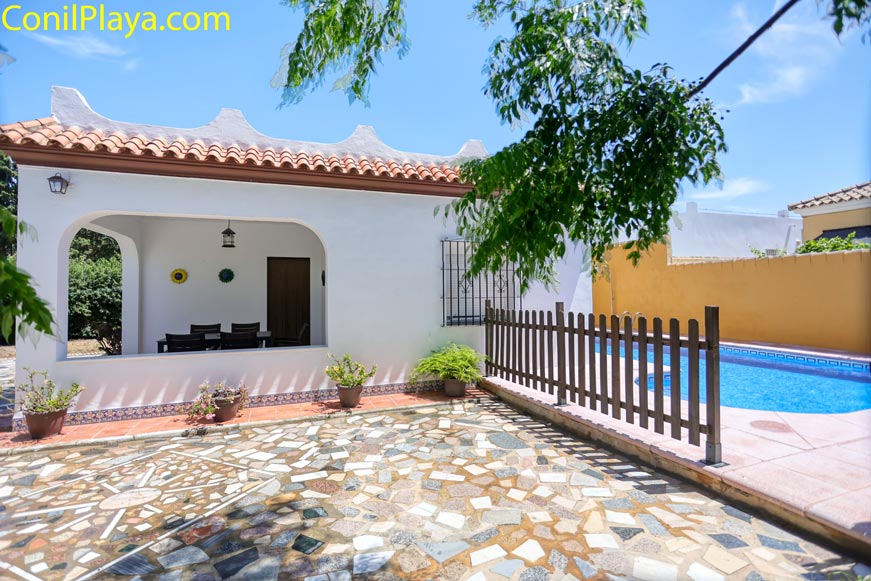 Vista del porche y piscina privada junto a la entrada principal de la casa