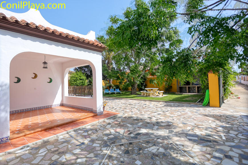 Zona pavimentada junto a un porche y jardín privado con barbacoa