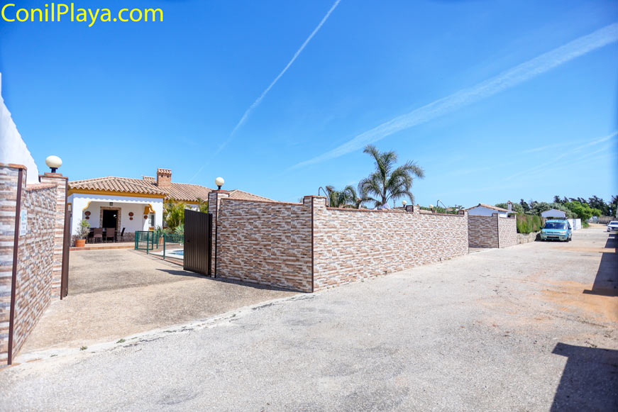 entrada a vivienda con vallado y patio junto a calle asfaltada