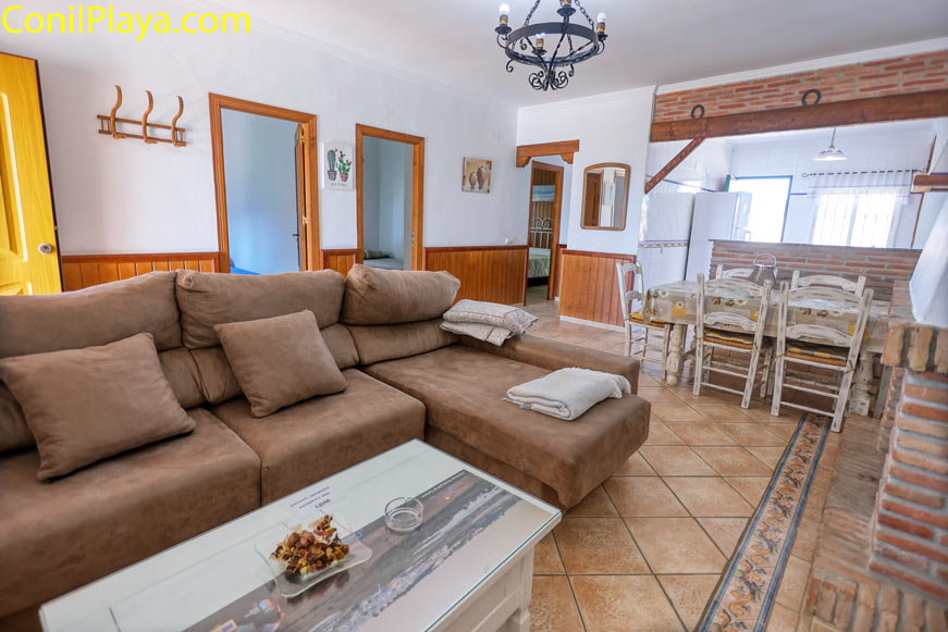 salón amplio con sofá en ele mesa centro y comedor junto a cocina
