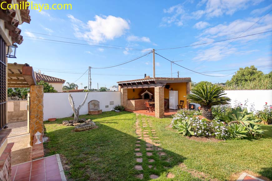 jardín y al fondo la barbacoa techada