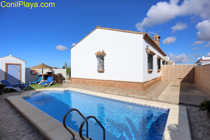 La piscina y al fondo la casa.